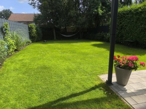 a yard with a green lawn with a pole and flowers at Ferienhaus Heide in Bad Fallingbostel