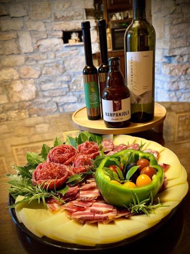 a plate of food on a table with wine bottles at Villa San Andrea - ideal for families, 8 adults, 2 children up to 5 years, 1 children up to 1 years in Svetvinčenat