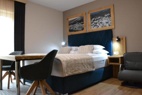 a hotel room with a bed and a table and chairs at Apartmány Špacír celý dům in Harrachov