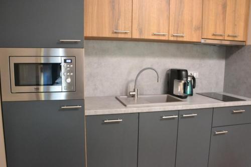 a kitchen with a sink and a microwave at Apartmány Špacír celý dům in Harrachov