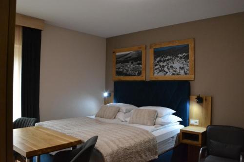 a bedroom with a bed and a desk and a table at Apartmány Špacír celý dům in Harrachov