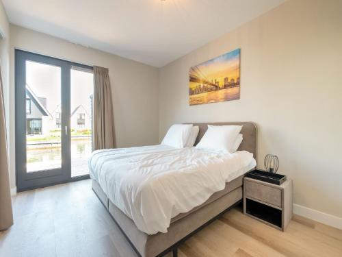 a bedroom with a large bed and a window at Holiday Home in Stavoren with Jetty in Stavoren