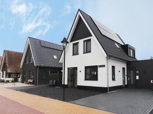 a white and black house with a black roof at Holiday Home in Stavoren with Jetty in Stavoren