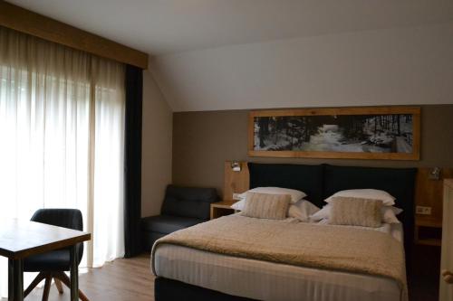 a bedroom with a bed and a table and a desk at Apartmány Špacír celý dům in Harrachov
