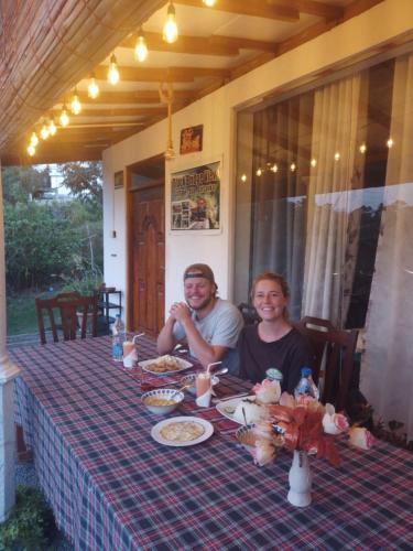 a man and a woman sitting at a table at Ella Black Bridge View Cottage Sri Lanka in Ella