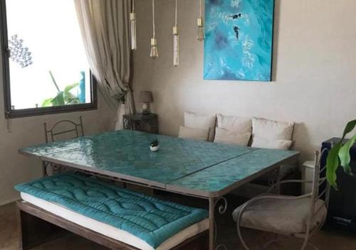 a table with a bench with a glass top at Dar Mogador Sun near Taghazout - Surf, Sea, colorful village in Taghazout