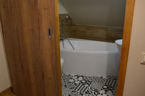 a bathroom with a bath tub and a toilet at Apartmány Špacír celý dům in Harrachov