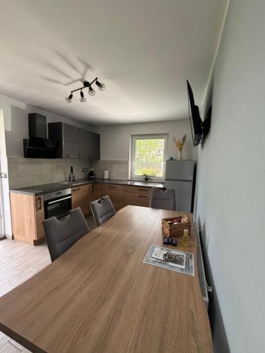 a kitchen with a large wooden table in a room at Apartments Kolačko in Bohinj