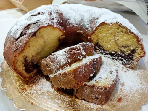 a bundt cake with powdered sugar on a glass plate at Hotel San Francesco in San Giovanni Rotondo