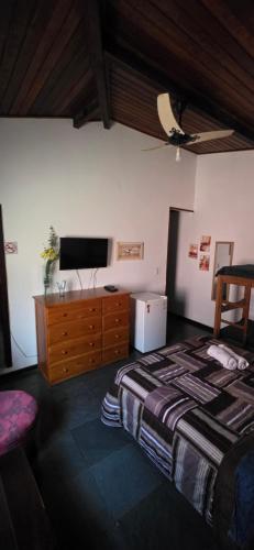 a bedroom with a bed and a flat screen tv at Encantos do mar in Arraial do Cabo