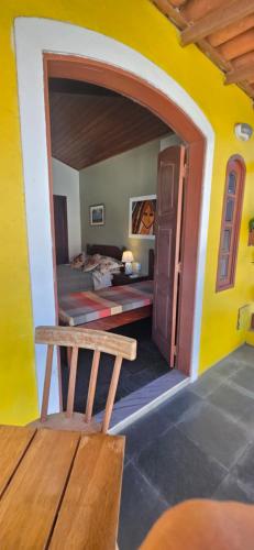 a room with a bed and a wooden bench at Encantos do mar in Arraial do Cabo