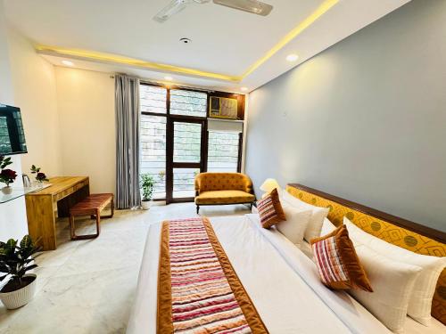 a bedroom with a bed and a couch and a chair at Grove Residency Hauz Khas Couple Friendly New Delhi in New Delhi