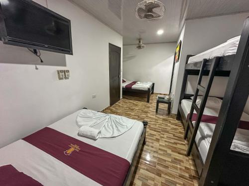 a room with two bunk beds and a flat screen tv at HOTEL COLONIAL santorini colombiano in Doradal