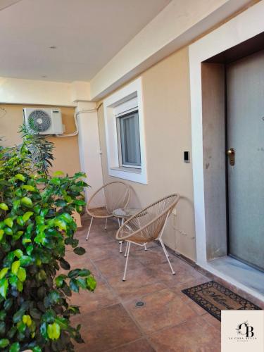 a patio with two chairs and a door at La casa bella di Chalkida 2 in Chalkida