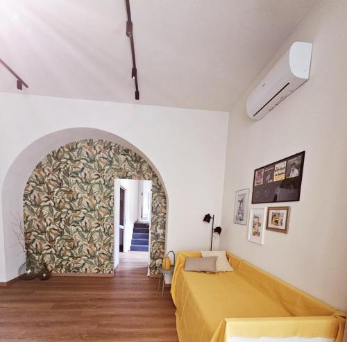 een slaapkamer met een geel bed en een boog bij Loft Fossati in La Spezia