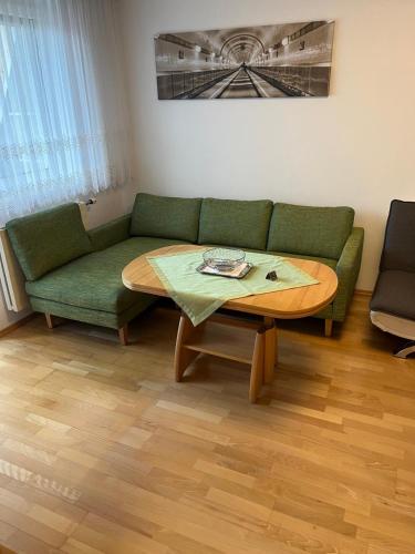 a living room with a green couch and a table at Tina`s Ferienwohnung in Kapfenberg
