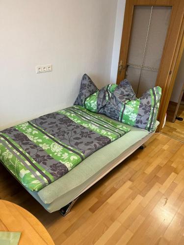 a bed in a room with green sheets and pillows at Tina`s Ferienwohnung in Kapfenberg