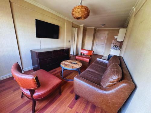 a living room with a couch and chairs and a table at Torremolinos departamentos in Temuco