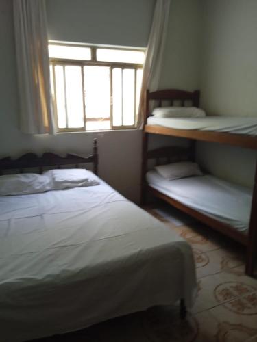 a bedroom with two bunk beds and a window at Oeste Lapa Hotel in Bom Jesus da Lapa