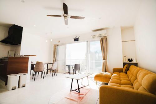 a living room with a couch and a table at 恩納村仲泊海の見える2LDkアパート in Onna