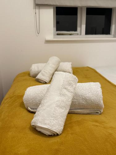 a group of towels sitting on top of a bed at Golden Oak Two bed Apartment in Erith