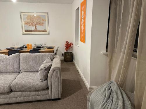 a living room with a couch and a table at Golden Oak Two bed Apartment in Erith