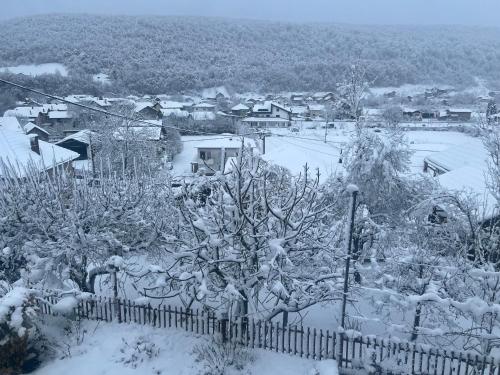 a garden covered in snow with a fence at SWISS Apartment in Pokoj