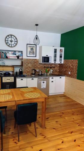 a kitchen with a wooden table and a green wall at Pod Papugami in Srebrna Góra