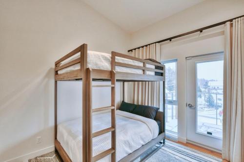 a bedroom with two bunk beds and a window at Tremblant mountain view PH71 in Mont-Tremblant