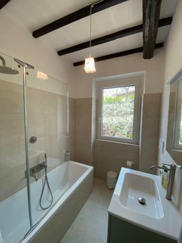 a bathroom with a tub and a sink and a window at Villa Donati in Piegaro