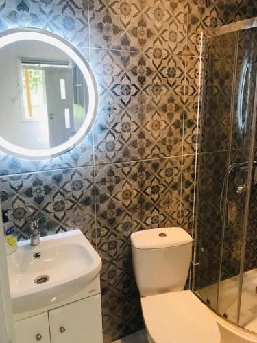 a bathroom with a toilet and a sink and a mirror at Mazury - Ruś domki wypoczynkowe nad samym jeziorem in Ruś