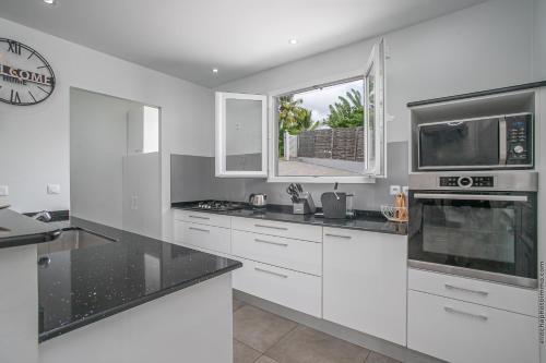 a kitchen with white appliances and a window at Villa Sweet Paradise in Le Lamentin