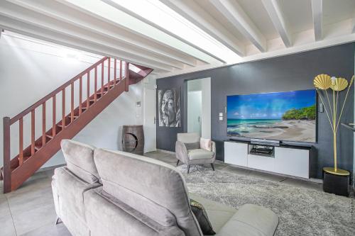 a living room with a couch and a tv at Villa Sweet Paradise in Le Lamentin