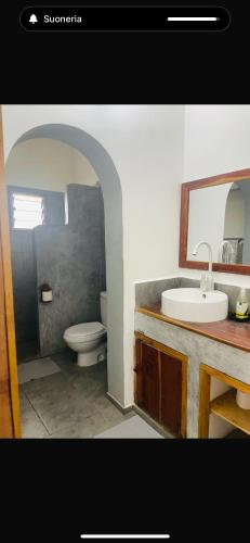 a bathroom with a sink and a toilet at Poa Poa Villas in Watamu