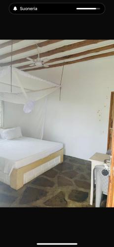 a bedroom with a white bed and a table at Poa Poa Villas in Watamu