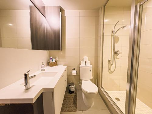 a bathroom with a sink and a toilet and a shower at Comfy Front Wellington Suites CN Tower Rogers Centre & Free Parking in Toronto