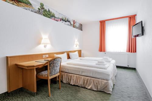 a hotel room with a bed and a desk at Hotel Domschatz in Quedlinburg