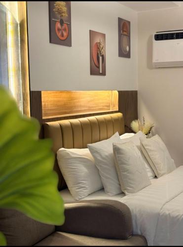a bedroom with a bed with white pillows at CASA UMBER - JTOWER behind SM JMALL in Mandaue City