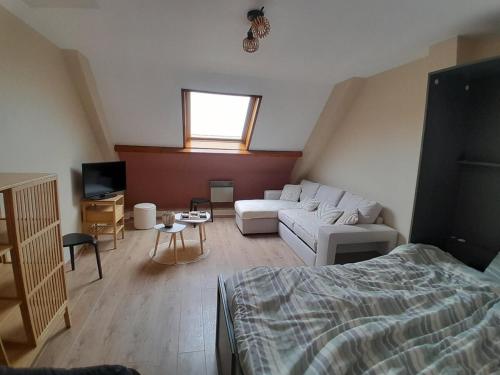 キュクにあるAppartement Stella plageのソファとベッドのあるリビングルーム