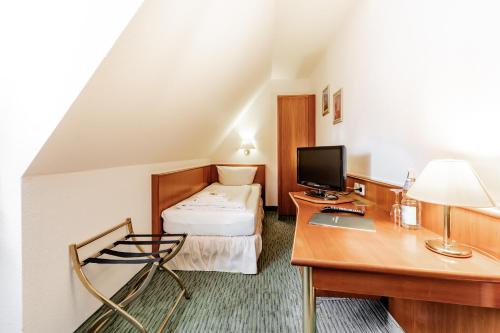 a hotel room with a desk and a bed at Hotel Domschatz in Quedlinburg