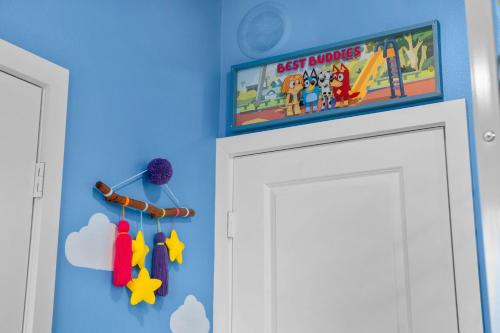 a room with a tv above a white door at Enchanted Dreams: Theater, Arcades, Playground + in Neff