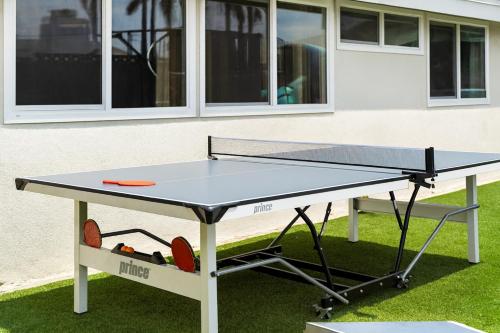 a ping pong table in front of a building at Enchanted Dreams: Theater, Arcades, Playground + in Neff