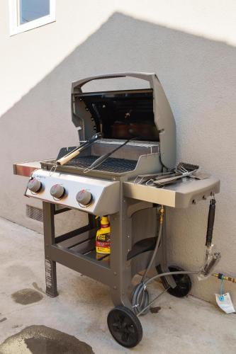 a bbq grill sitting next to a wall at Enchanted Dreams: Theater, Arcades, Playground + in Neff
