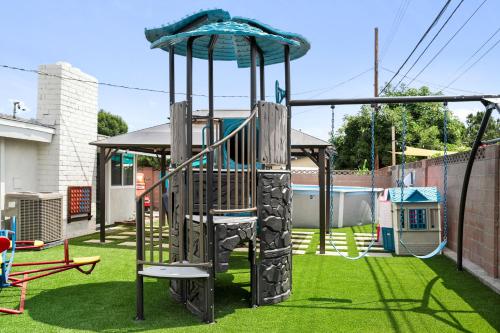 a playground with a slide in a yard at Enchanted Dreams: Theater, Arcades, Playground + in Neff