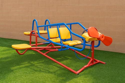 a colorful childrens playground equipment on the grass at Enchanted Dreams: Theater, Arcades, Playground + in Neff