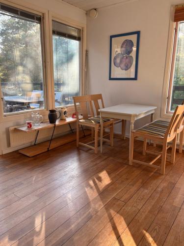 a living room with a table and chairs and windows at Villa Villekulla in Åhus