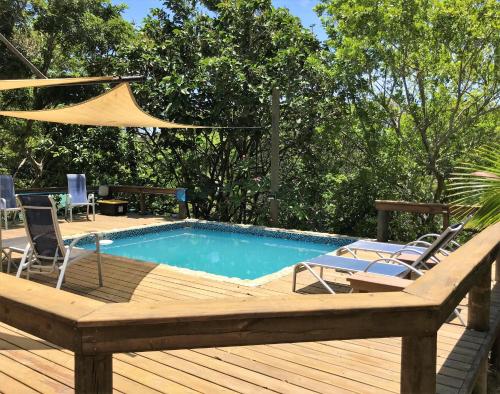 a pool on a deck with chairs and a hammock at Quiet Retreat, Ideal For An Intimate Romantic Getaway Or 2 Couples in Roatan