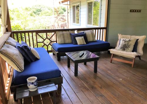 a porch with two couches and a table and a chair at Quiet Retreat, Ideal For An Intimate Romantic Getaway Or 2 Couples in Roatan