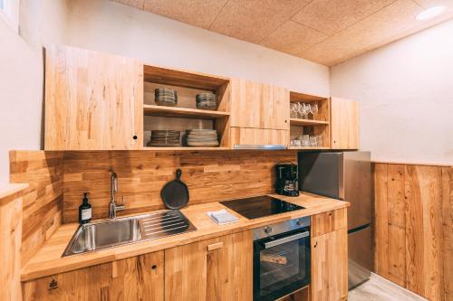 a kitchen with wooden cabinets and a sink at Möttelin Gut Hügle in Ravensburg