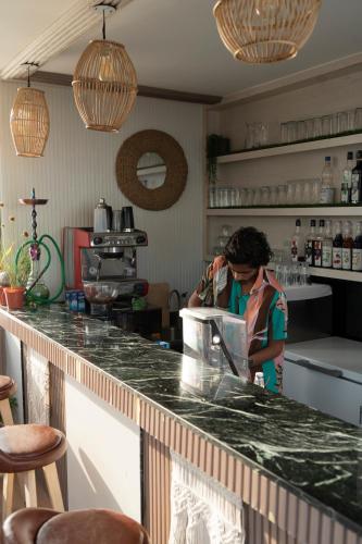a woman standing at a counter in a kitchen at Nest by Hawks Hotels Kamadhoo Baa Atoll in Kamadhoo